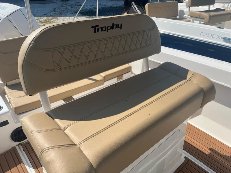 Slide: The Image of 2025 Bayliner Trophy T22CC boat seat with tan upholstery and "Trophy" logo. - 13