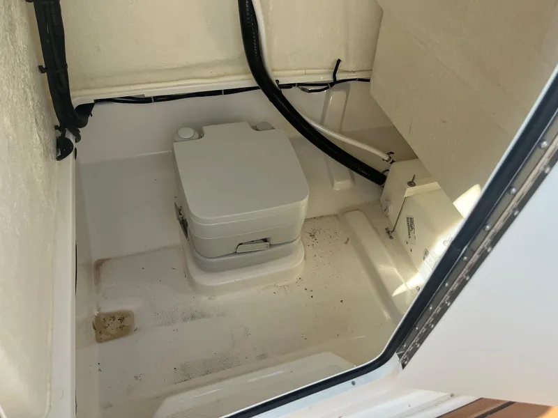Slide: The Image of 2025 Bayliner Trophy T22CC boat interior with portable toilet. - 16
