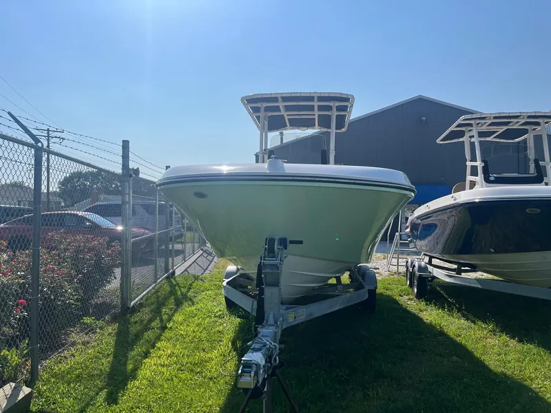 Slide: The Image of 2025 Bayliner Trophy T22CC boat on trailer, parked outdoors under clear sky. - 3