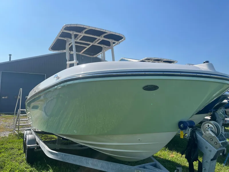 Slide: The Image of 2025 Bayliner Trophy T22CC boat on trailer under clear blue sky. - 4