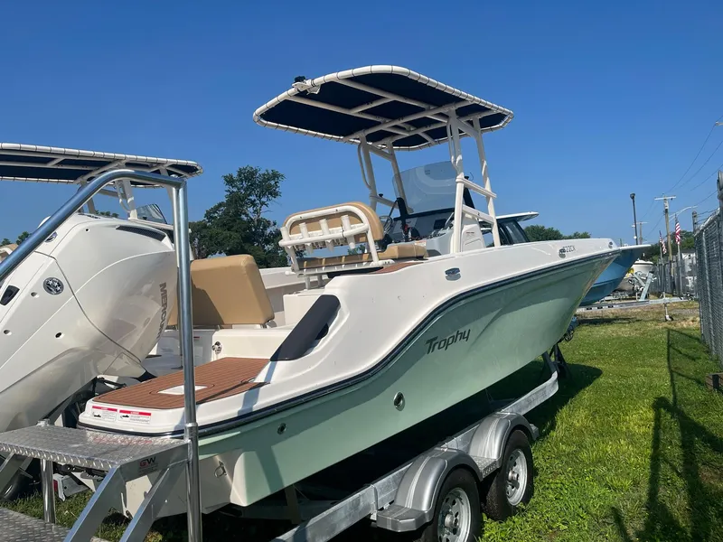 Slide: The Image of 2025 Bayliner Trophy T22CC boat on trailer under clear blue sky. - 5