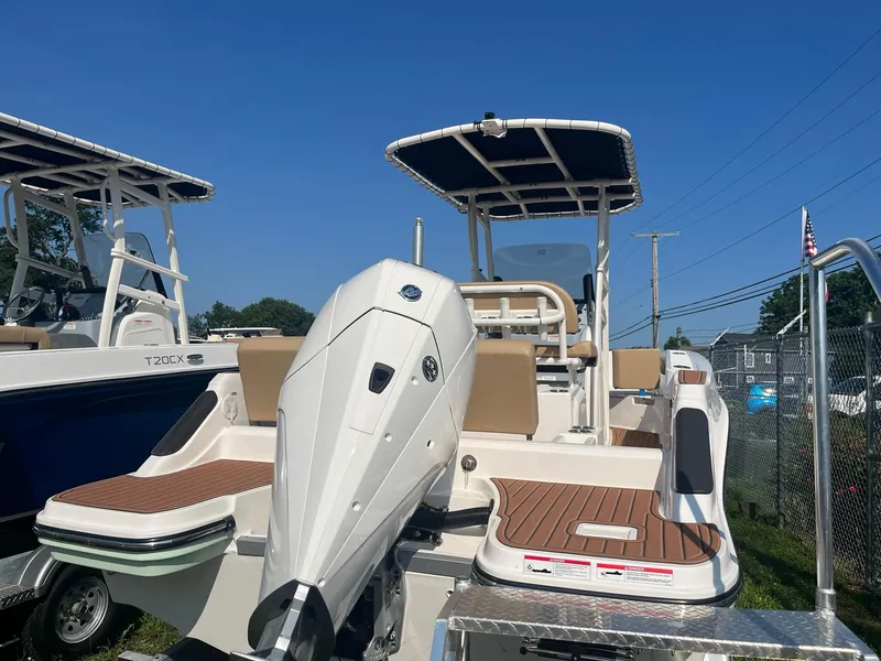 Slide: The Image of 2025 Bayliner Trophy T22CC boat with outboard motor, docked under clear blue sky. - 6
