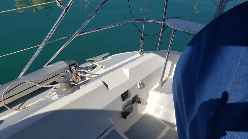 Slide: The Image of 1989 Hunter Legend 37 sailboat cockpit with winch and ropes, docked on calm water. - 12