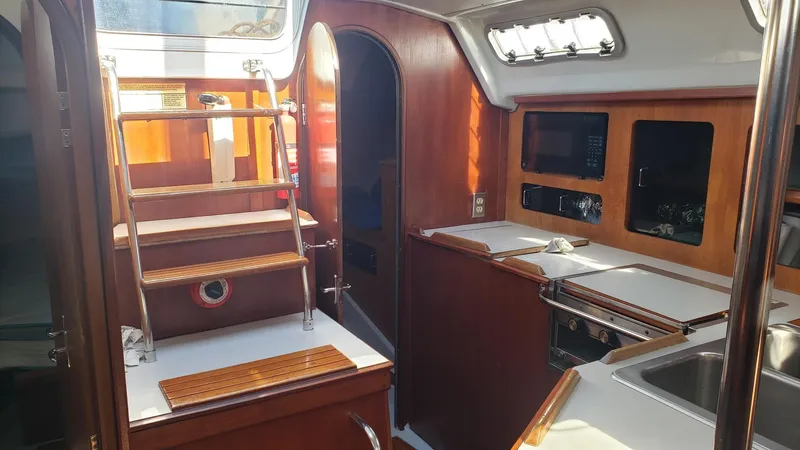 Slide: The Image of Interior of 1989 Hunter Legend 37 sailboat with wooden cabinetry and compact kitchen area. - 18