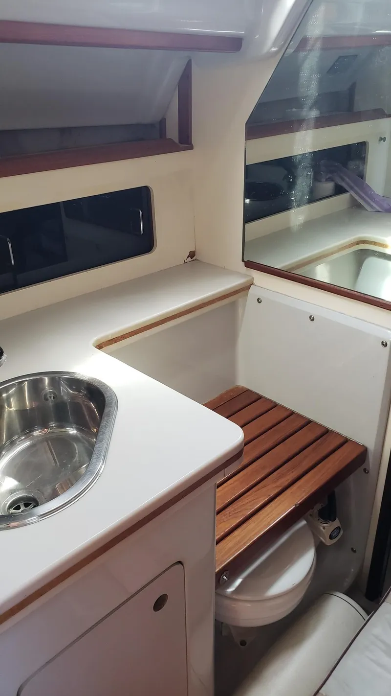 Slide: The Image of 1989 Hunter Legend 37 yacht interior with sink, wooden bench, and compact design. - 19