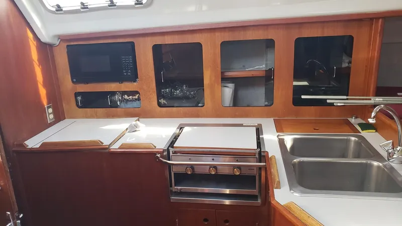 Slide: The Image of 1989 Hunter Legend 37 yacht kitchen with stove, sink, and wooden cabinetry. - 20