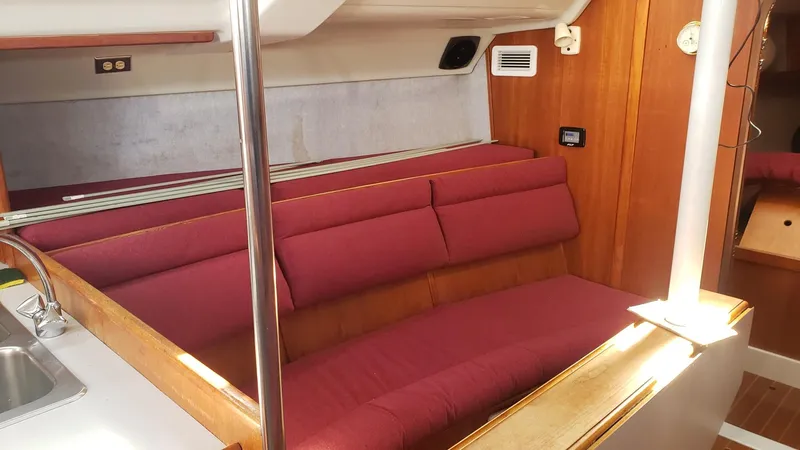 Slide: The Image of Interior of 1989 Hunter Legend 37 sailboat with red seating and wooden accents. - 23