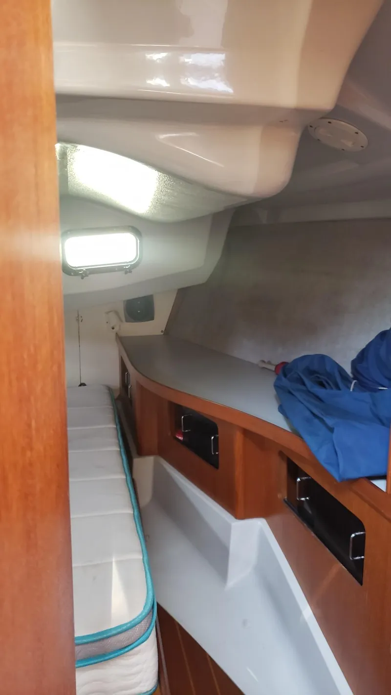 Slide: The Image of 1989 Hunter Legend 37 yacht interior with cozy sleeping quarters and wooden cabinetry. - 28