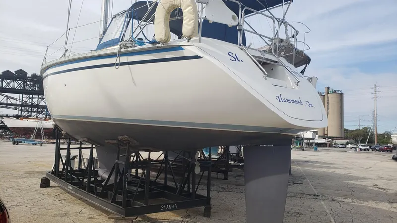Slide: The Image of 1989 Hunter Legend 37 sailboat on dry dock, white hull, blue accents, marina background. - 35
