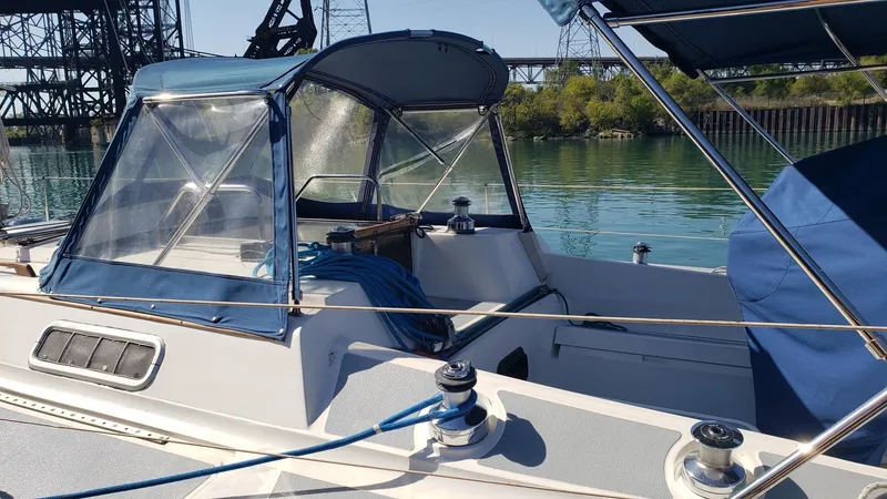 Slide: The Image of 1989 Hunter Legend 37 sailboat with blue canopy, docked on a sunny day. - 8
