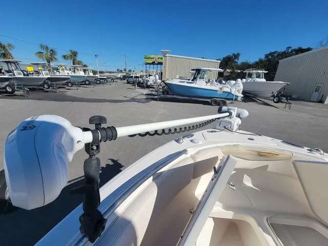 Slide: The Image of 2016 Robalo R222 boat with trolling motor in a marina setting. - 12