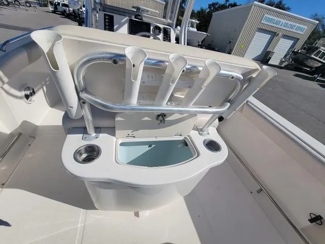 Slide: The Image of 2016 Robalo R222 boat with rod holders and livewell in a marina setting. - 16