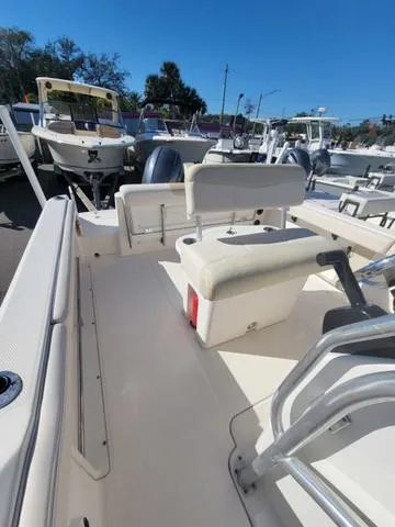 Slide: The Image of 2016 Robalo R222 boat interior with seating and console, docked under clear blue sky. - 23