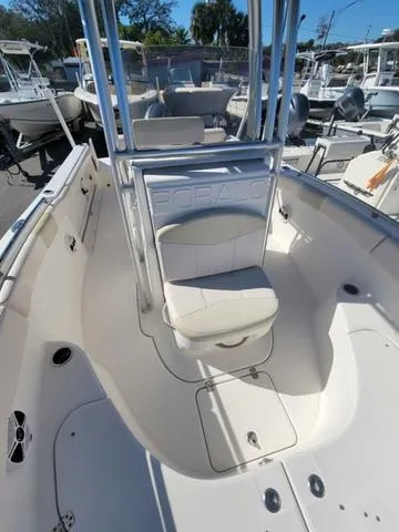 Slide: The Image of 2016 Robalo R222 boat interior with seating and console, docked among other boats. - 25