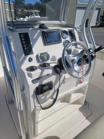 Slide: The Image of 2016 Robalo R222 boat console with steering wheel and navigation controls. - 27