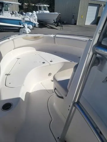 Slide: The Image of 2016 Robalo R222 boat interior with seating and storage, docked at a marina. - 28