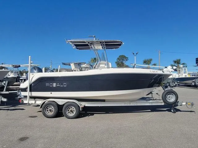 Slide: The Image of 2016 Robalo R222 boat on trailer, parked outdoors under clear blue sky. - 3