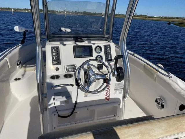 Slide: The Image of 2016 Robalo R222 boat cockpit with steering wheel and control panel on a sunny day. - 40
