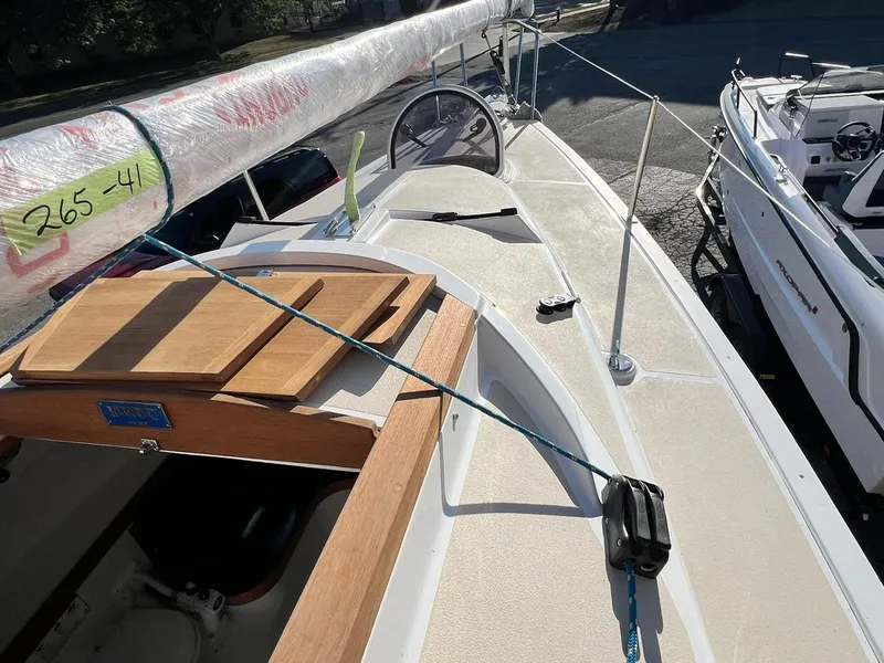 Slide: The Image of 2025 Tartan Fantail sailboat deck with wrapped mast and wooden hatch cover. - 10