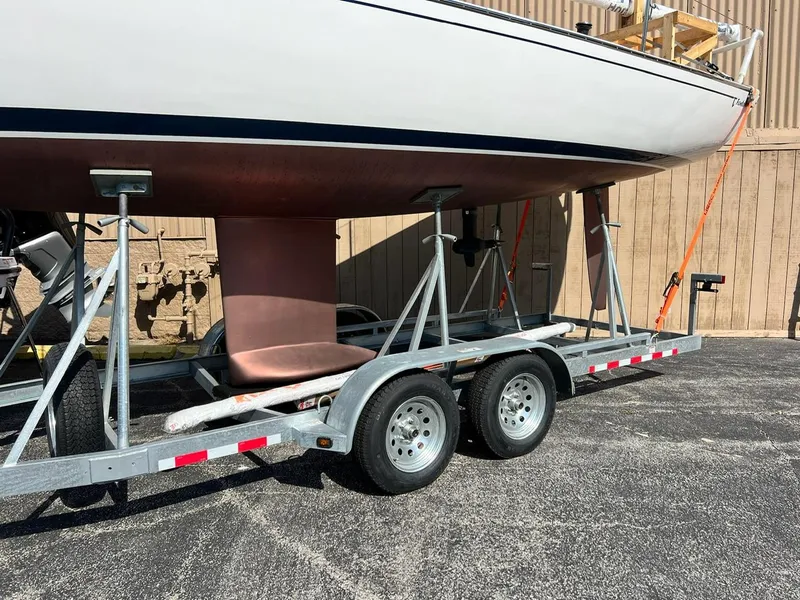 Slide: The Image of 2025 Tartan Fantail sailboat on a trailer, parked outdoors. - 3