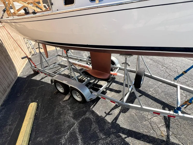 Slide: The Image of 2025 Tartan Fantail sailboat on a trailer, parked on asphalt. - 4