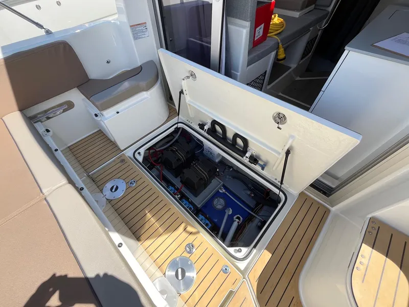 Slide: The Image of 2025 Bayliner Trophy T25 Explorer boat interior with open storage compartment. - 13