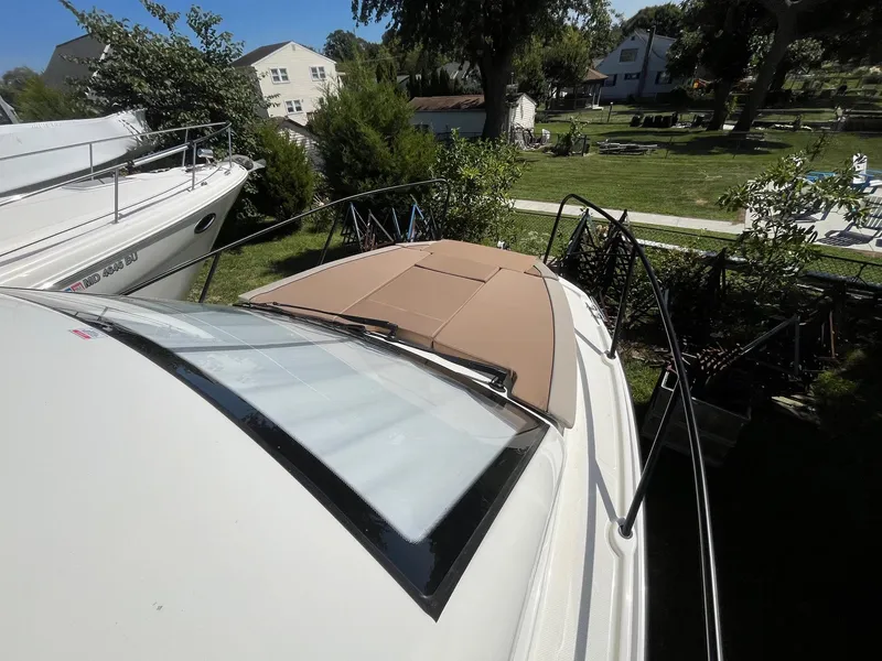 Slide: The Image of 2025 Bayliner Trophy T25 Explorer boat with sunroof, docked in a residential area. - 16