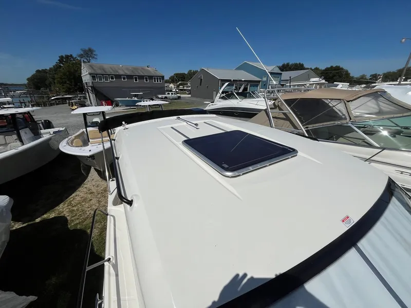 Slide: The Image of 2025 Bayliner Trophy T25 Explorer boat docked, showcasing sleek design and rooftop hatch. - 17