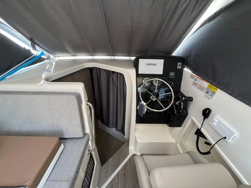 Slide: The Image of 2025 Bayliner Trophy T25 Explorer helm with steering wheel and seating area. - 18