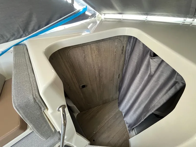 Slide: The Image of Interior cabin of 2025 Bayliner Trophy T25 Explorer with wood finish and curtain. - 20