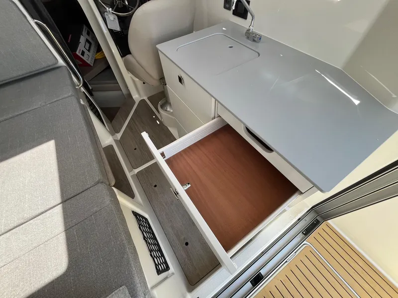 Slide: The Image of 2025 Bayliner Trophy T25 Explorer interior with open drawer and compact sink. - 29