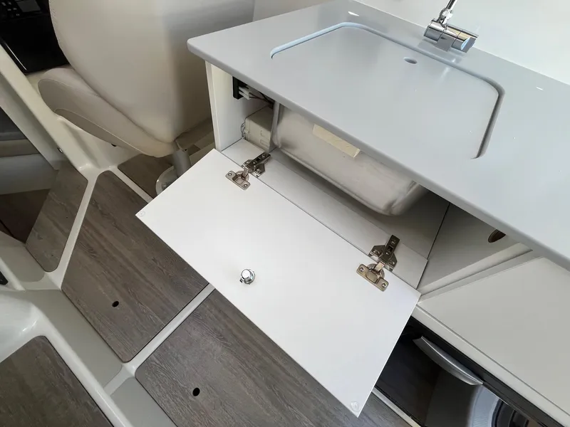 Slide: The Image of 2025 Bayliner Trophy T25 Explorer interior with open storage compartment and modern design. - 30