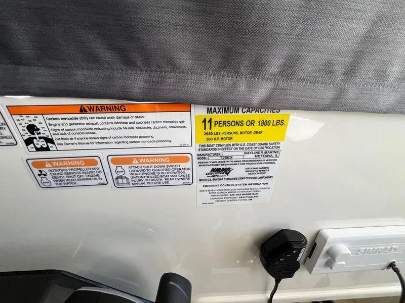 Slide: The Image of Warning labels on 2025 Bayliner Trophy T25 Explorer boat, showing maximum capacity of 11 persons. - 36