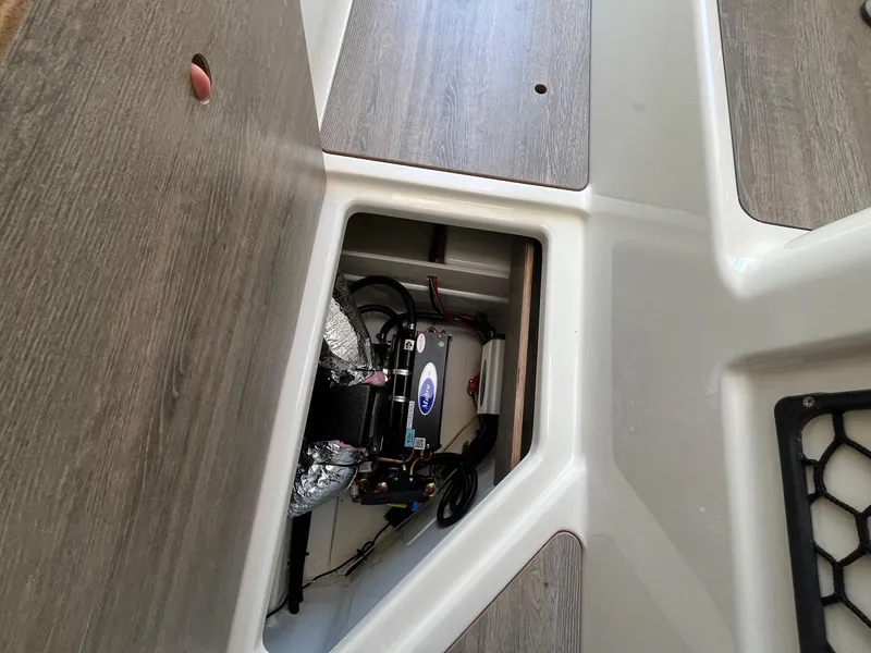 Slide: The Image of 2025 Bayliner Trophy T25 Explorer storage compartment with visible equipment and wiring. - 40