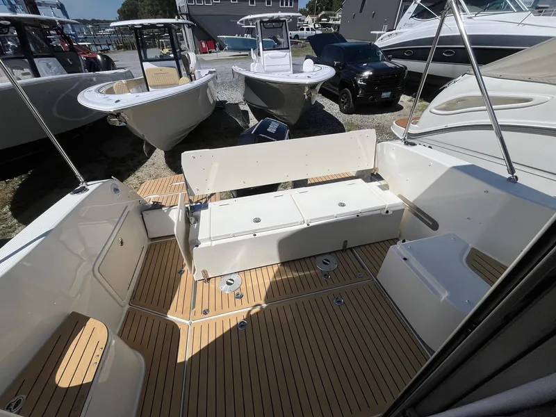 Slide: The Image of 2025 Bayliner Trophy T25 Explorer boat interior with seating and wood flooring. - 42