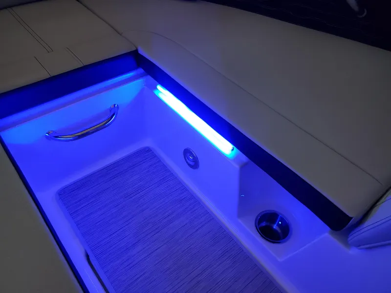 Slide: The Image of 2025 Sea Ray SPX 230 boat interior with blue LED lighting and sleek design. - 33