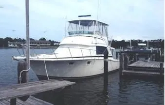 Slide: The Image of 1981 Bertram Convertible boat docked at a marina, showcasing classic design and sturdy build. - 16
