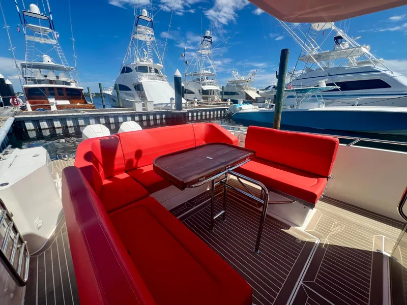 Slide: The Image of Red seating area on 2022 Nimbus T11 #98 TRADE! yacht, docked with other boats. - 19