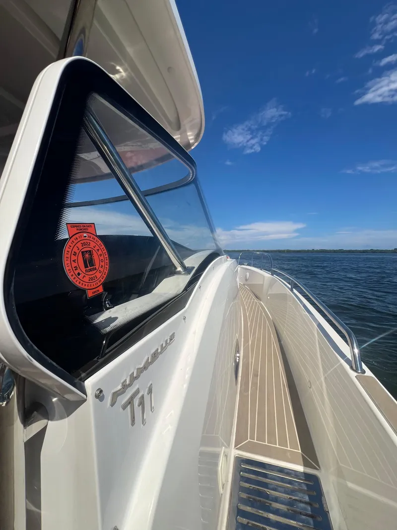 Slide: The Image of 2022 Nimbus T11 boat on water, showcasing sleek design and clear blue sky. - 22