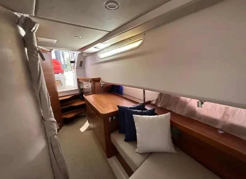 Slide: The Image of Cozy interior of 2022 Nimbus T11 #98 TRADE! boat with wooden furnishings and cushions. - 27