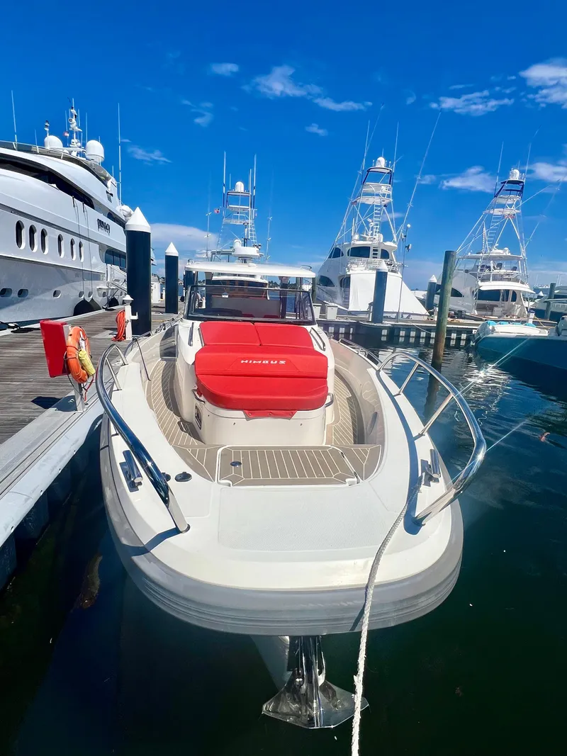 Slide: The Image of Nimbus T11 #98 TRADE! 2022 boat docked at marina, clear sky, luxury yachts in background. - 4