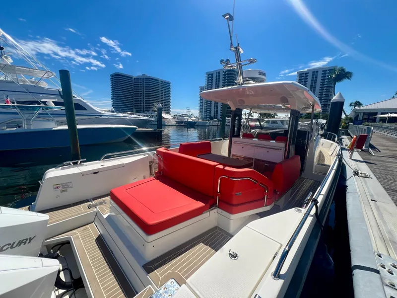 Slide: The Image of 2022 Nimbus T11 #98 TRADE! boat with red seating docked at marina. - 6
