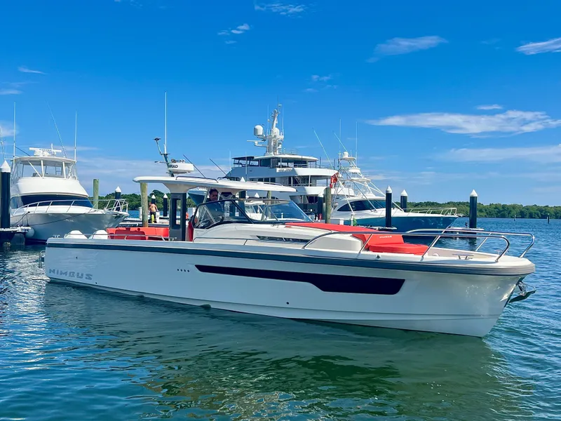 Slide: The Image of 2022 Nimbus T11 #98 TRADE! boat docked in a marina under a clear blue sky. - 13