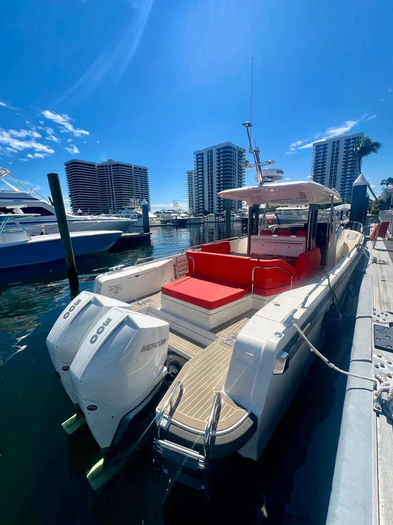 Slide: The Image of 2022 Nimbus T11 #98 TRADE! boat docked with twin outboard engines and red seating. - 7