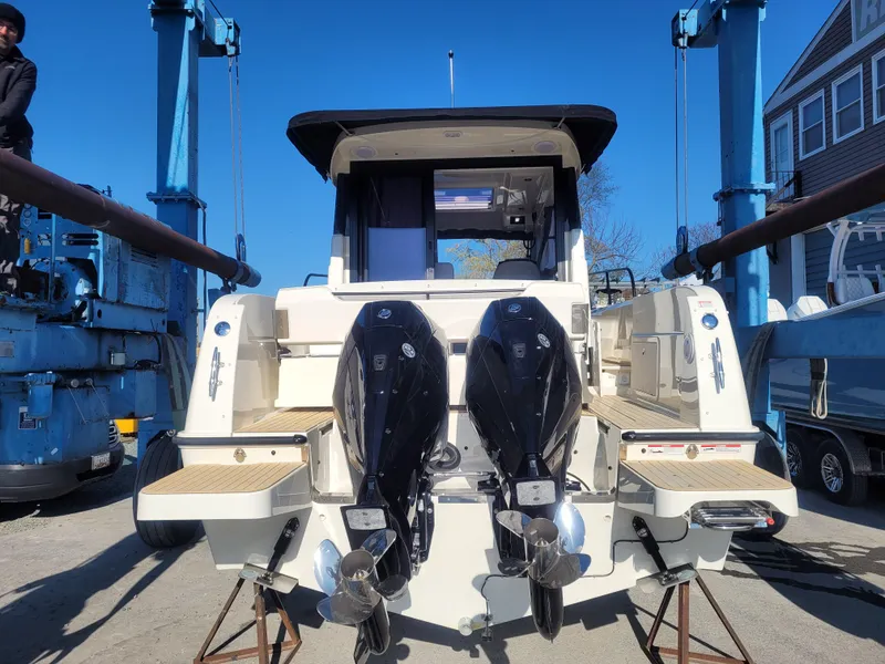 Slide: The Image of 2025 Bayliner Trophy T29 Explorer with dual outboard motors on a boat lift. - 15