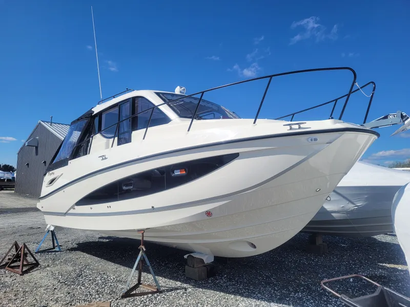 Slide: The Image of 2025 Bayliner Trophy T29 Explorer boat on display, elevated on stands, under clear blue sky. - 3