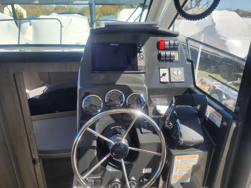 Slide: The Image of 2025 Bayliner Trophy T29 Explorer helm with modern controls and navigation system. - 8