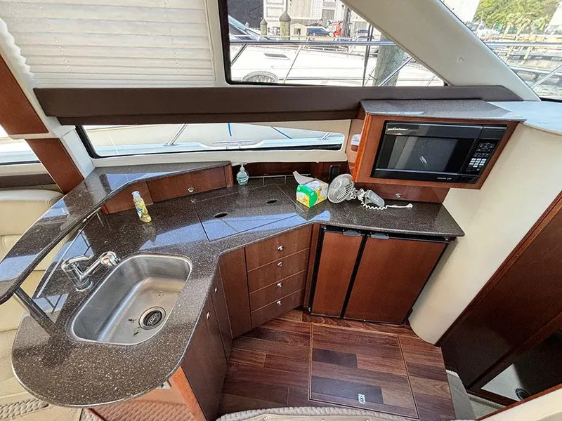 Slide: The Image of 2011 Meridian 391 Sedan yacht kitchen with sink, microwave, and wooden cabinetry. - 18