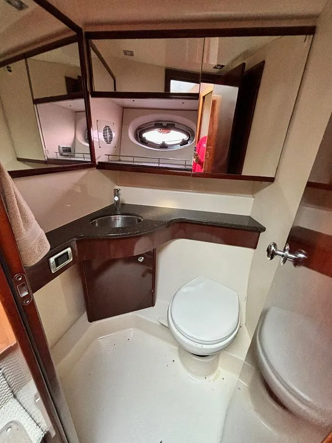 Slide: The Image of 2011 Meridian 391 Sedan bathroom with sink, toilet, and mirrored cabinets. - 22