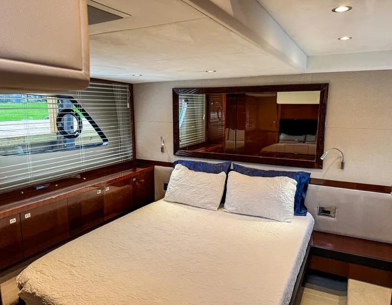 Slide: The Image of Luxurious 2015 Princess V52 yacht bedroom with elegant wood finishes and large window. - 20